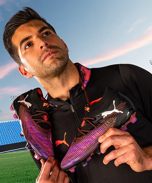 Campaña Puma FUTURE producida por ZerezoFilms: jugador con tachones negros y morados sobre los hombros en un estadio al atardecer